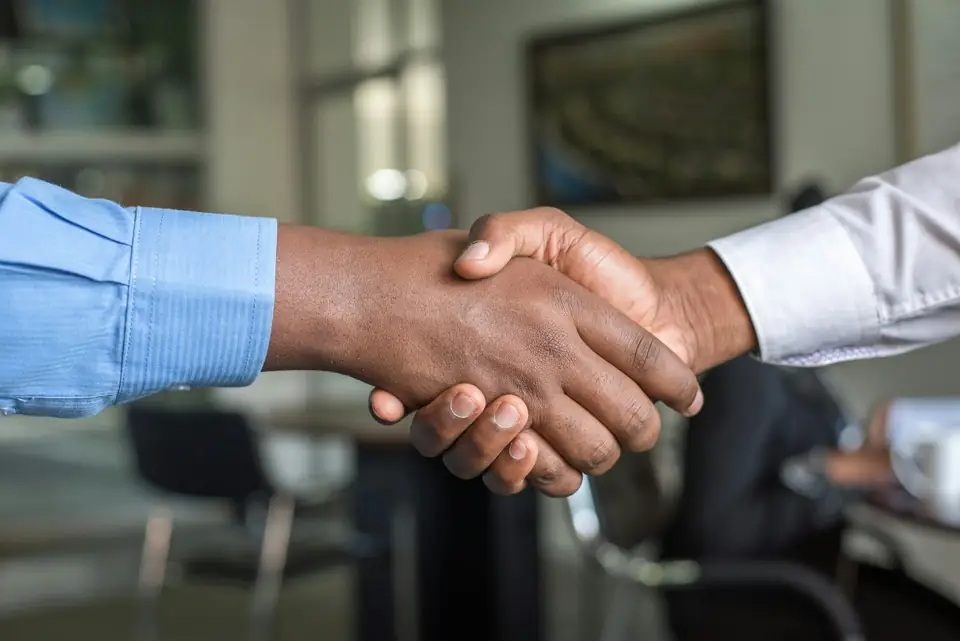 Two business people shaking hands in an office
